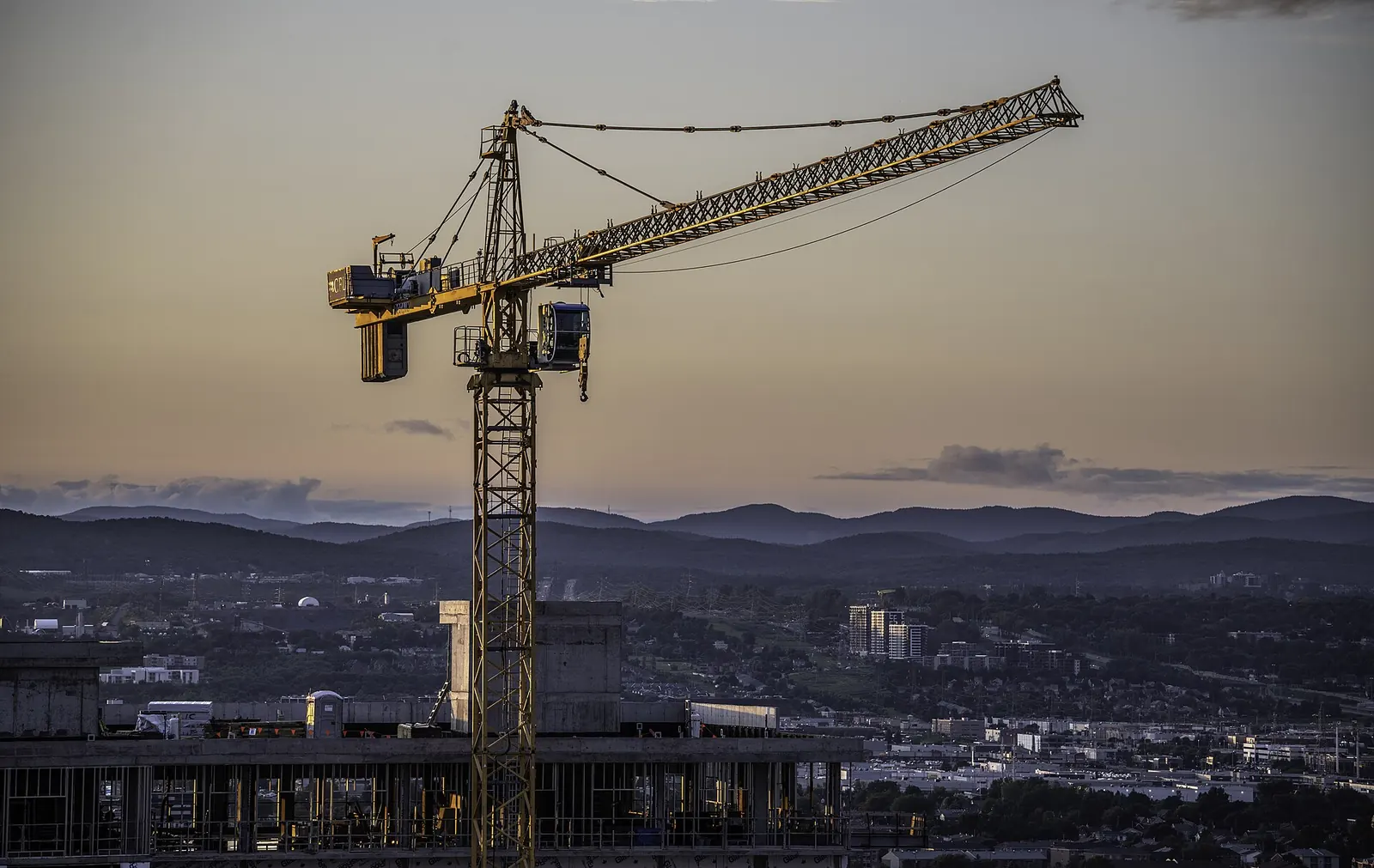 Tower crane over a construction site at dusk
